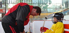 Nejmenším hokejistům pomáhají trenéři se zavazováním bruslí. Na snímku Jiří Cihlář a Filip Koláček. - Zdeněk Drla